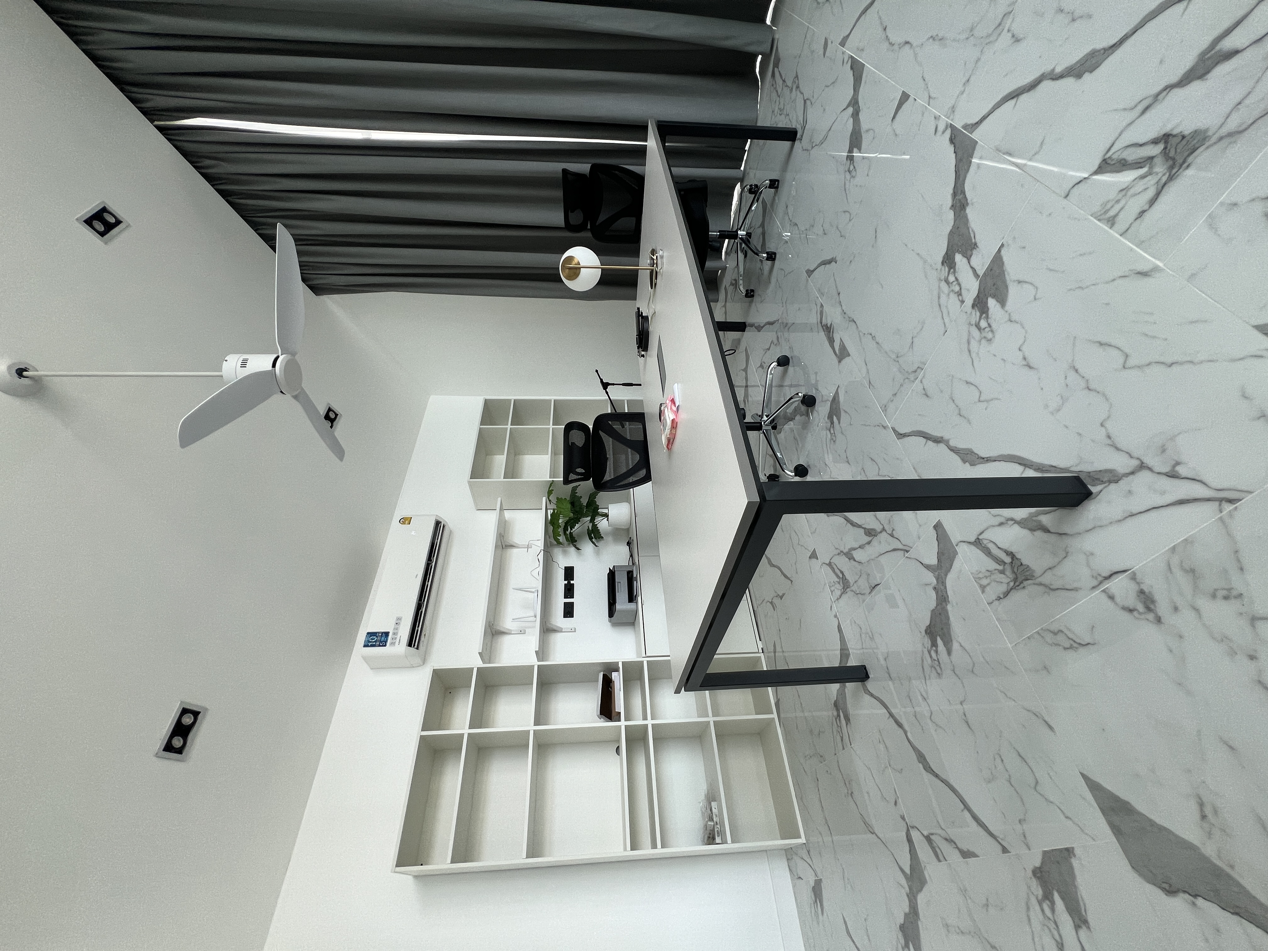 Modern home office with built-in shelving and marble flooring