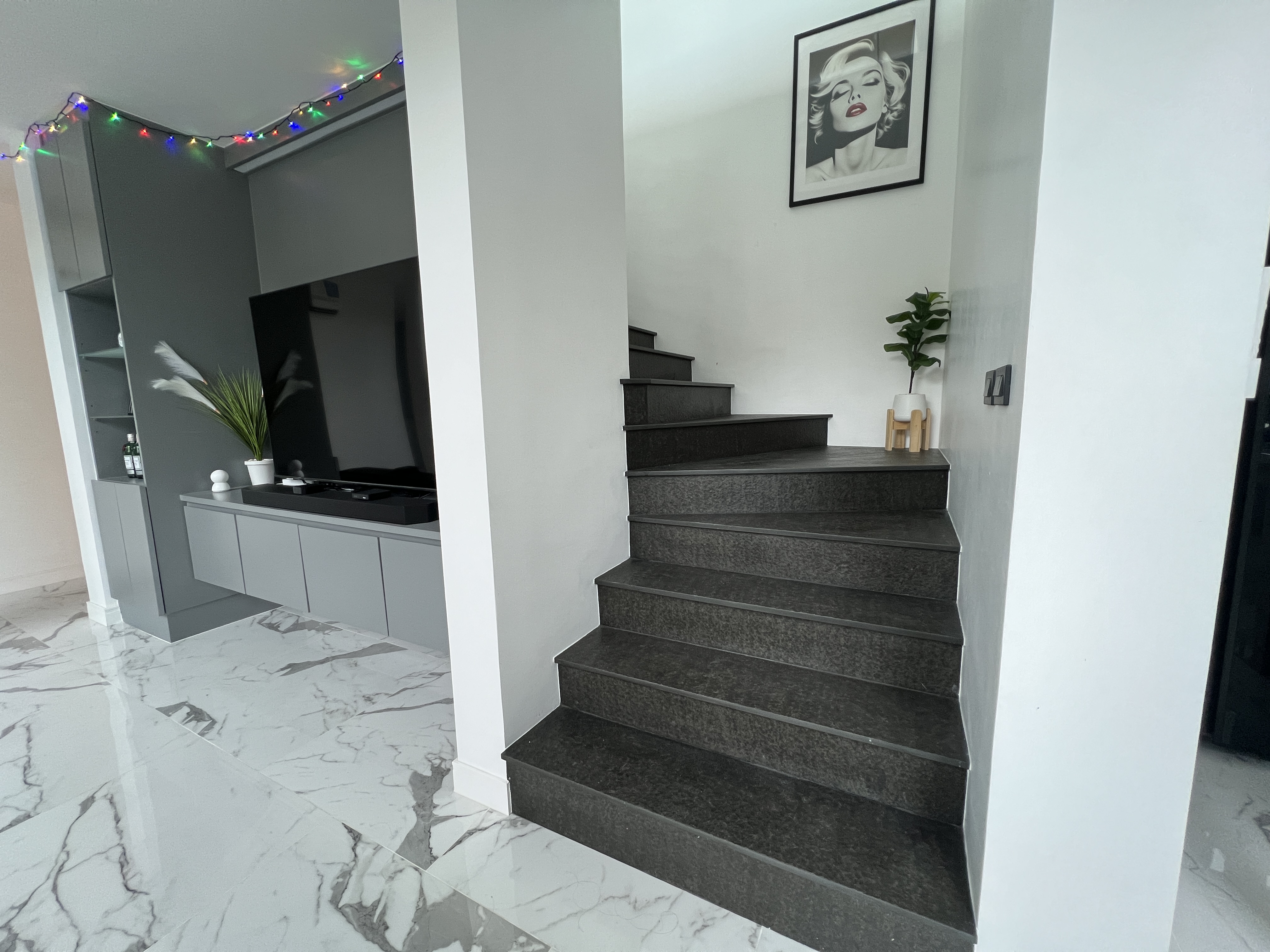 Elegant interior staircase with dark stone steps and marble flooring